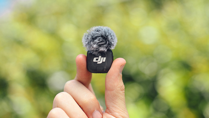 Nadajnik DJI Mic 3 czarny grafika przedstawia nadajnik trzymany w ręku